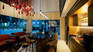 un restaurante con un bar con mesa y sillas en ST Signature Bugis Middle, SHORT OVERNIGHT, 11 hours 8PM-7AM, en Singapur