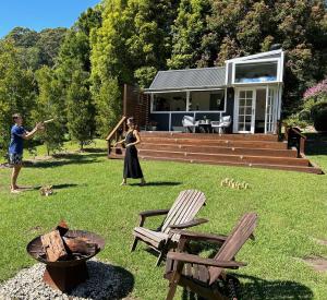 a man and a woman playing frisbee in a yard at Central Coast Deck and Spa Luxury Tiny House with firepit in Matcham