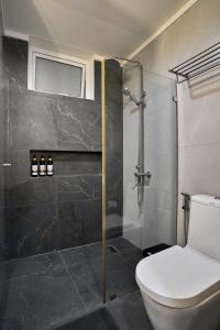a bathroom with a toilet and a glass shower at Yugen Suites 208 at Pico De Loro in Nasugbu