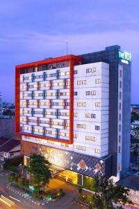 a hotel building with a lit up sign on it at THE 1O1 Palembang Rajawali in Palembang