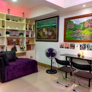 a living room with a purple couch and a table at Cozy Condo Unit w/ FREE WIFI&Netflix-Pay Parking in Antipolo