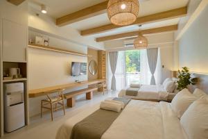 a hotel room with two beds and a television at Yugen Suites 208 at Pico De Loro in Nasugbu