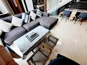- un salon avec un canapé, des tables et des chaises dans l'établissement Custom Design Loft With City Views And Rooftop Pool, à Makkasan