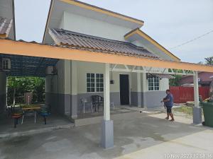 a man standing in front of a house at MRI Residence - Homestay in Sg Buloh with Swimming Pool - No Pork&Alcohol Allowed in Bandar Puncak Alam