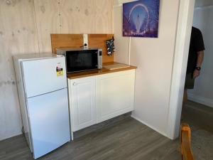 a kitchen with a white refrigerator and a microwave at Nambucca Lodge in Nambucca Heads