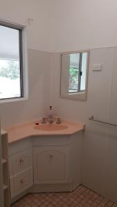 ein Bad mit einem Waschbecken und einem Spiegel in der Unterkunft Billungar Unit 1 at Hat Head in Hat Head