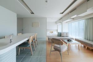 a kitchen and living room with a table and chairs at ITOMACHI HOTEL0 in Saijo