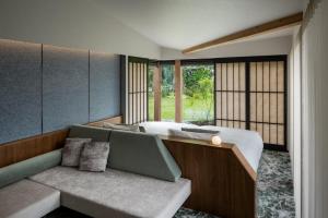 a bedroom with a bed and a couch and windows at ITOMACHI HOTEL0 in Saijo