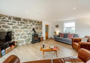 a living room with a stone wall at Brynhynog Fawr in Llangwnadl