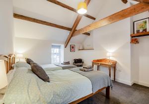 a bedroom with two beds and a table at Brynhynog Fawr in Llangwnadl