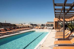 a large swimming pool with lounge chairs and a building at Mount Vernon 2BR w WD Gym nr Chinatown WDC-565 in Washington