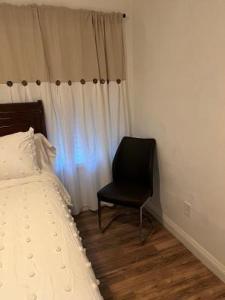 um quarto com uma cadeira ao lado de uma cama em Private Room em Rialto