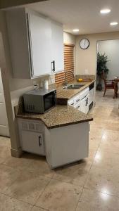 a kitchen with a sink and a microwave on a counter at Private Room in Rialto