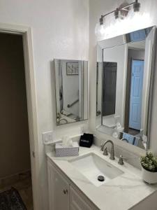 a white bathroom with a sink and two mirrors at Private Room in Rialto