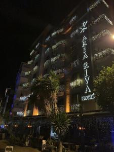 a hotel with a sign on the side of it at night at Aria Riva Apart Hotel in Alanya
