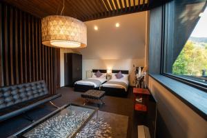 山形市にあるユニテ蔵王ジョーニダ リゾートのベッド1台、ソファ、窓が備わる客室です。