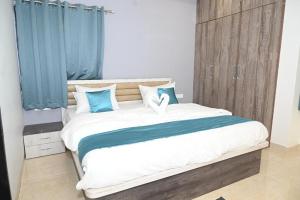 a bedroom with a large bed with blue curtains at SMS Dream Homestay in Amargol