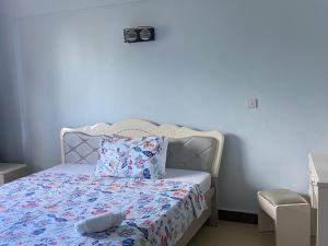 a bedroom with a bed with a blue wall at Beachfront M. A.apartment in Dar es Salaam