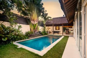Villa Baik Baik by BaliSuperHost في سمينياك: مسبح في الحديقة الخلفية للمنزل