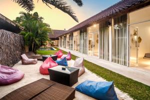 水明漾‎的住宿－Villa Baik Baik by BaliSuperHost，户外庭院配有色彩缤纷的枕头和桌子。