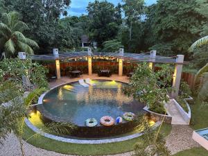 a swimming pool in a garden with a building at Hotel Dumaguete in Dumaguete