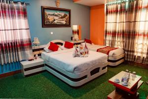 Duas camas num quarto com alcatifa verde em Hotel Everest Inn Pvt. Ltd. em Butwāl