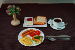 uma mesa com um prato de comida para o pequeno-almoço e uma chávena de café em Hotel Everest Inn Pvt. Ltd. em Butwāl