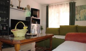 uma sala de estar com uma mesa e um sofá verde em Relax Home ®Rajna® em Korenica