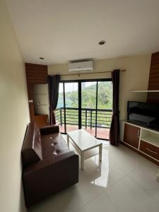 a living room with a leather couch and a table at Prautamnak Grand Apartments in Pattaya South