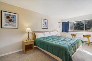 a bedroom with a bed and a table and a window at Pinnacle E25 in Killington +16 photos