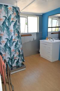 bagno con tenda per la doccia e lavandino di Kai Iwi Lakes Resort a Kaihu