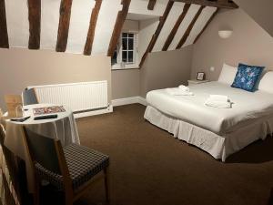 um quarto com uma cama, uma mesa e uma cadeira em Limes hotel em Needham Market