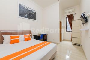 1 dormitorio con 1 cama grande y TV en Pondok Cimanggu Syariah Mitra RedDoorz, en Bogor