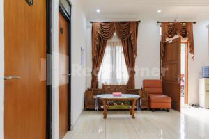 een kamer met een tafel, een stoel en een raam bij Pondok Cimanggu Syariah Mitra RedDoorz in Bogor