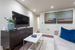 a living room with a couch and a tv at Garden Haven Luxe 1BR 1BA Chigwell Retreat CHCL F1 in Chigwell