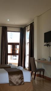 sypialnia z łóżkiem, biurkiem i oknem w obiekcie Revayah Hotels w mieście Ruteng