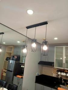 a kitchen with three lights hanging from the ceiling at Relaxing Studio at Morgan Suites walking distance Venice Piazza T219P in Manila