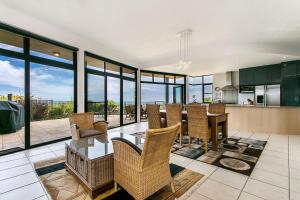 a kitchen and living room with a table and chairs at A Perfect Stay - Above Byron in Byron Bay