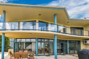 un edificio con balcón con mesa y sillas en A Perfect Stay - Above Byron en Byron Bay