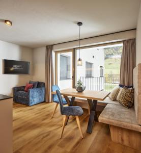 a living room with a table and a couch at Apart Galeon in Pettneu am Arlberg