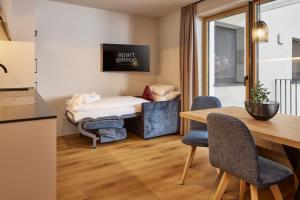a small room with a table and chairs and a bed at Apart Galeon in Pettneu am Arlberg