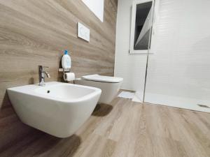 a bathroom with a white sink and a toilet at Casa Cristina in Comiso