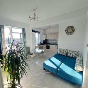 a living room with a blue bed and a kitchen at Highsky Oradea Apartments in Oradea