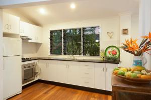 a kitchen with white cabinets and a bowl of fruit at A Perfect Stay - Aluna in Byron Bay