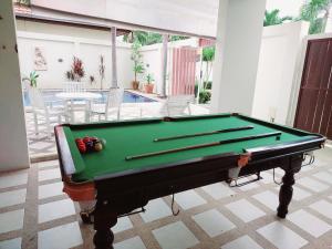 a pool table in the middle of a room with a swimming pool at AnB poolvilla 2BR with private beach in pratamnak in Pattaya South