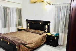 1 dormitorio con 1 cama grande y 2 ventanas en Oriental Arcadia Elegant Apartment in Gulshan 2, en Dhaka
