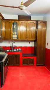 una cucina rossa con armadi in legno e pavimento rosso di Oriental Arcadia Elegant Apartment in Gulshan 2 a Dhaka