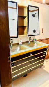 baño con lavabo y 2 espejos en Oriental Arcadia Elegant Apartment in Gulshan 2, en Dhaka