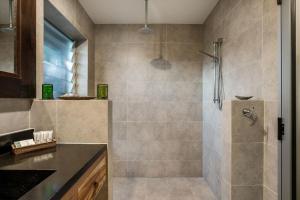 a bathroom with a shower with a glass door at A Perfect Stay - Brandon St Beach and Spa in Suffolk Park
