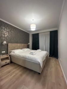 een slaapkamer met een groot bed met witte lakens bij Apartamente Cluj in Floreşti